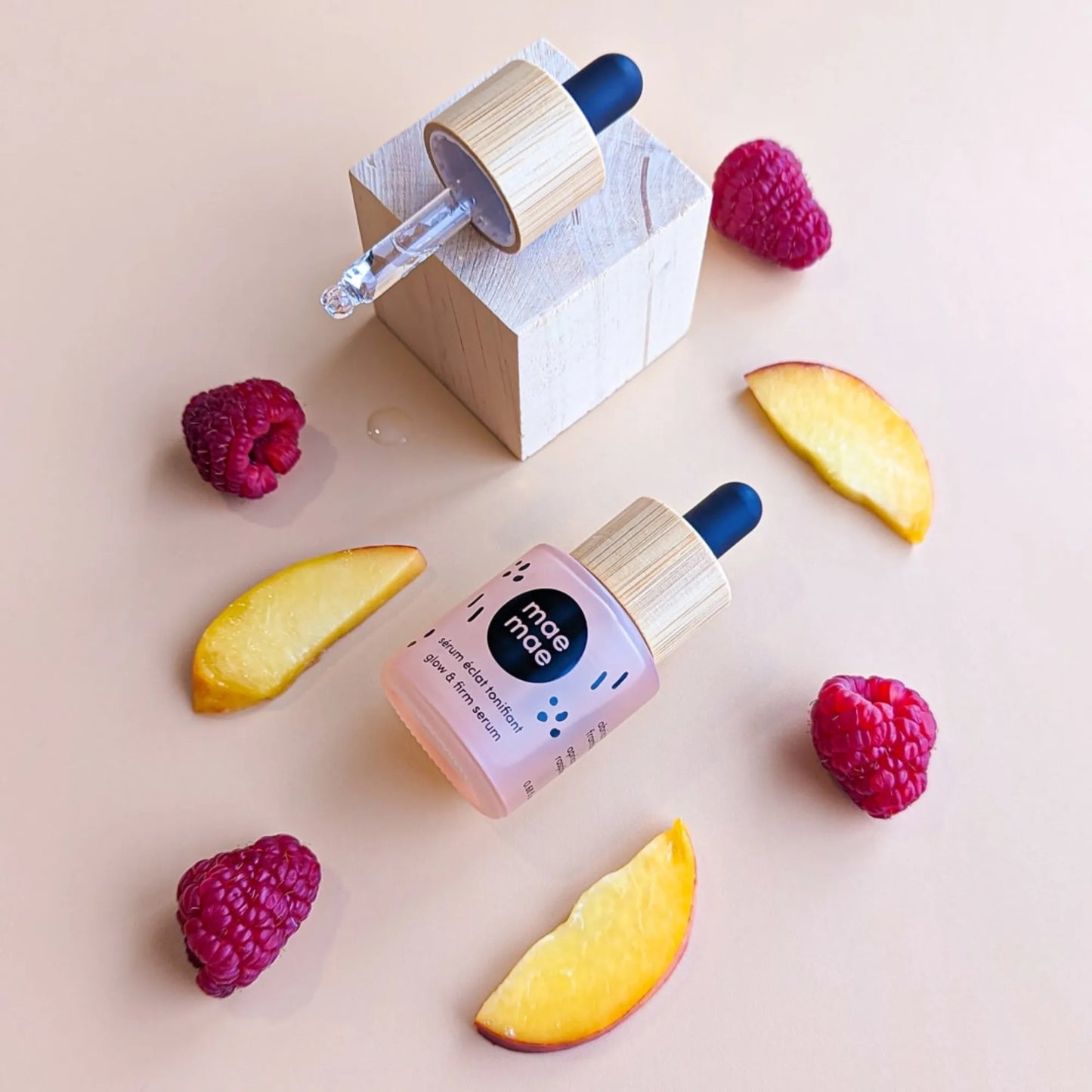 Sérum éclat tonifiant mae mae posé avec framboises et tranches d’abricot