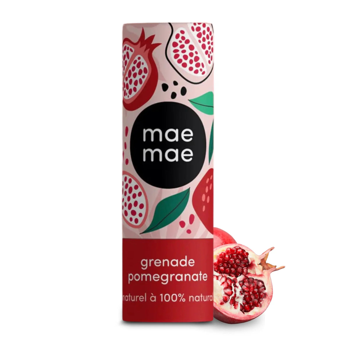 Mae Mae pomegranate‑tinted lip balm in a cylindrical tube with illustrated pomegranate patterns, standing upright next to a halved fresh pomegranate showing red seeds on a white background