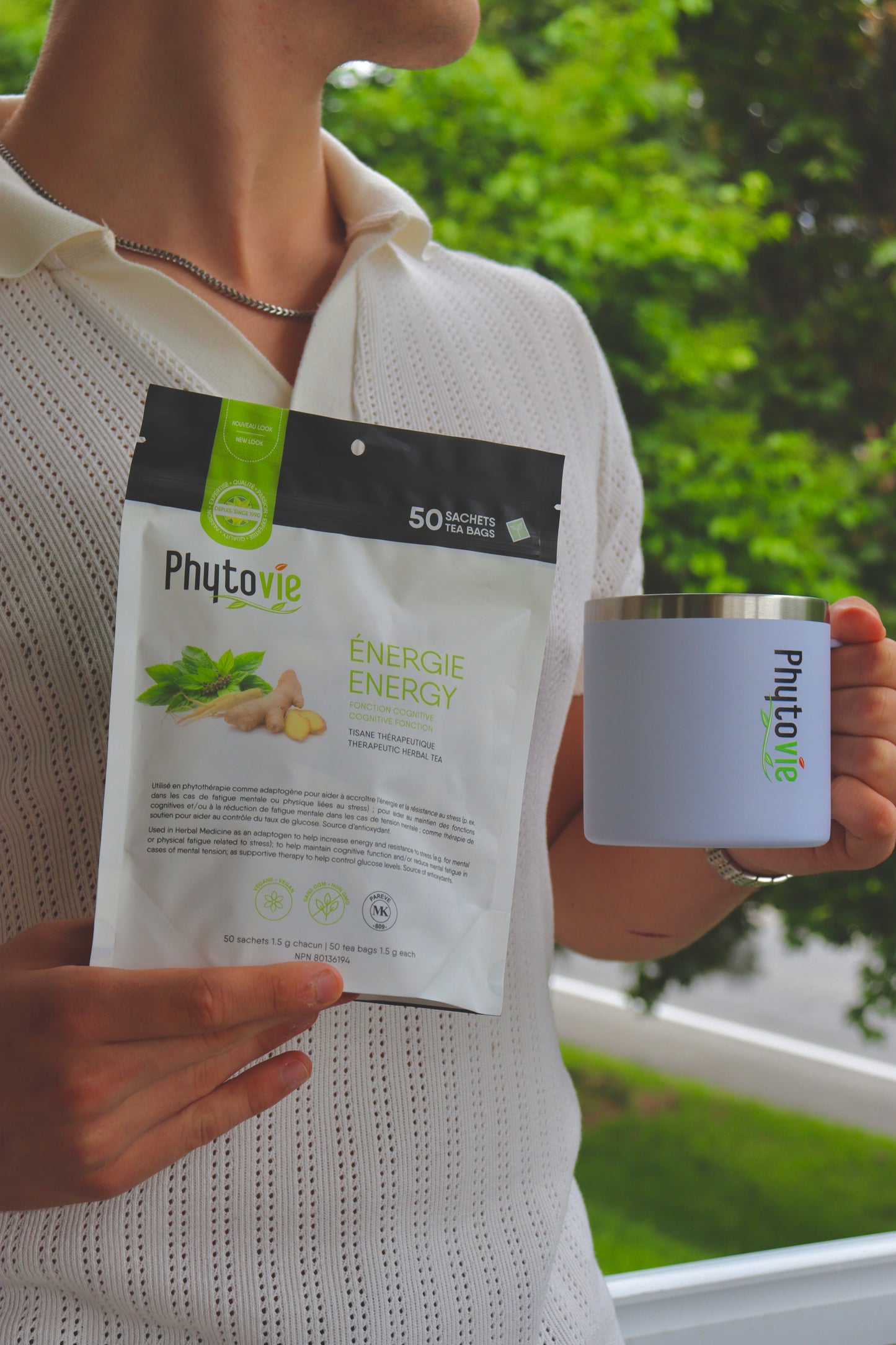 Image d’une personne tenant le sac de Tisane Énergie Phytovie et une tasse d’infusion, illustrant l’utilisation quotidienne et le moment bien-être.