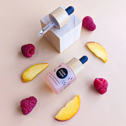 Sérum éclat tonifiant mae mae posé avec framboises et tranches d’abricot