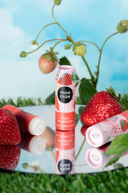 Baume à lèvres naturel à la fraise mae mae entouré de fraises fraîches