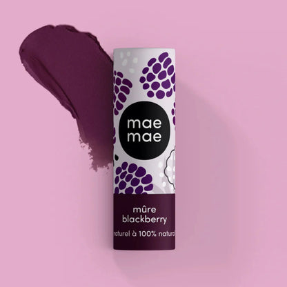 Baume à lèvres teinté Mae Mae mûre présenté avec une trace de texture mauve sur fond rose
