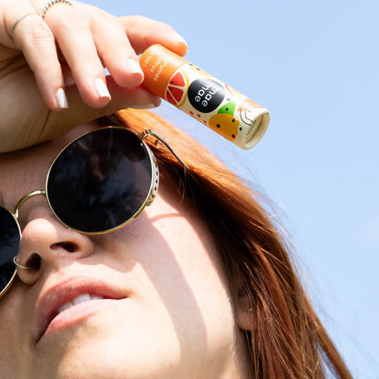 Baume à lèvres naturel aux agrumes mae mae utilisé en extérieur par une femme