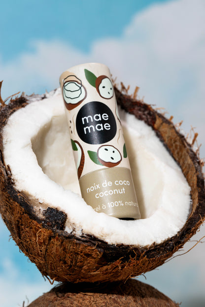 Baume à lèvres naturel à la noix de coco mae mae posé dans une noix de coco fraîche