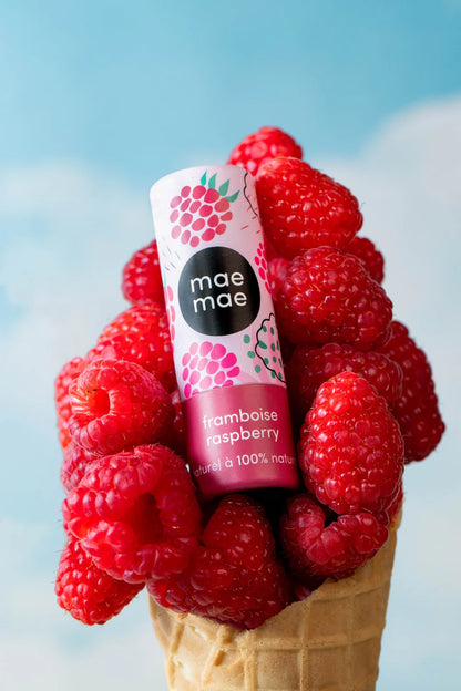Baume à lèvres naturel framboise mae mae posé dans un cornet de framboises fraîches