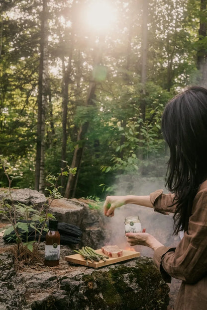 Sel aromatique sauvage Gourmet Sauvage en utilisation dans un décor naturel du Québec, ambiance forêt et plein air mettant en valeur un assaisonnement authentique et riche en saveurs