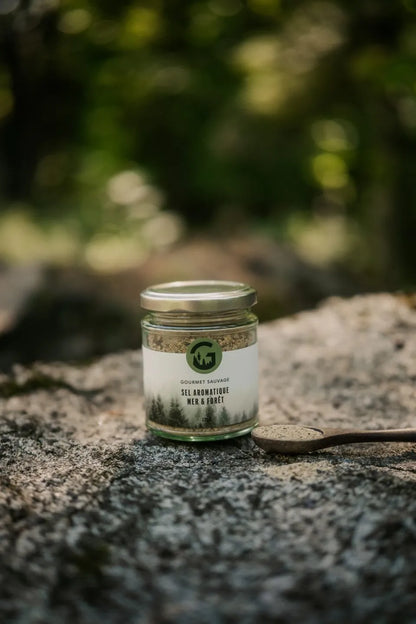 Sel aromatique sauvage Gourmet Sauvage en utilisation dans un décor naturel du Québec, ambiance forêt et plein air mettant en valeur un assaisonnement authentique et riche en saveurs